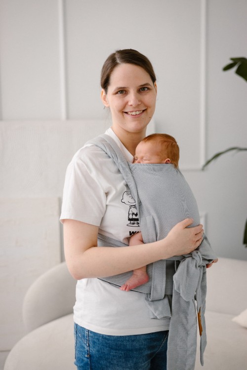 Modelka-nosi-dziecko-w-ergonomicznym-nosidle-KAVKA-handy-verona-twill----szare-nosidlo-z-delikatnym-wzorem-w-jodelke-a-gray-carrier-with-a-subtle-twill-pattern.jpg